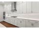 Modern kitchen with stainless steel appliances, white cabinets, and hardwood floors at 779 Keystone Dr, Woodstock, GA 30188