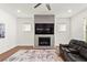 Modern living room with a fireplace, large TV, recessed lights, area rug, and a leather sofa at 779 Keystone Dr, Woodstock, GA 30188
