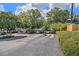 Gated entrance to the apartment community with mature trees, landscaping, and paved entry road at 1150 Collier Nw Rd # A1, Atlanta, GA 30318