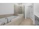 Modern bathroom featuring a soaking tub, a glass-enclosed shower, and tile flooring at 5440 Howington Ct # 190, Buford, GA 30518