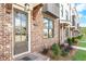 Charming townhome entrance with brick facade, covered entryway, and lush landscaping at 5440 Howington Ct # 190, Buford, GA 30518