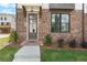 Welcoming townhome entrance with brick facade, covered entryway, and lush landscaping at 5440 Howington Ct # 190, Buford, GA 30518