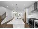 Bright, open kitchen featuring island with quartz countertop, stainless steel appliances, and hardwood floors at 5440 Howington Ct # 190, Buford, GA 30518