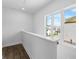 Landing area featuring hardwood floors, white walls, and a large window overlooking the neighborhood at 5440 Howington Ct # 190, Buford, GA 30518
