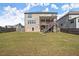 Spacious backyard featuring a well-maintained lawn, a wooden fence, and a covered back deck with stair access at 7410 Ansley View Ln, Cumming, GA 30028