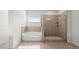 Well-lit bathroom featuring a separate tub and walk-in shower with gray stone tiling at 7410 Ansley View Ln, Cumming, GA 30028