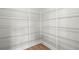 Walk-in closet featuring customizable shelving for efficient organization and storage, with natural wood-look floors at 7410 Ansley View Ln, Cumming, GA 30028