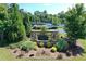 Welcome to Ansley Park: A beautiful entrance with lush landscaping and visible tennis courts at 7410 Ansley View Ln, Cumming, GA 30028