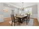 Bright dining room with light hardwood flooring and a modern chandelier fixture at 7410 Ansley View Ln, Cumming, GA 30028