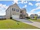 Beautiful home with a stone and brick facade, attached garage and green lawn on a sunny day at 7410 Ansley View Ln, Cumming, GA 30028