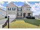 Charming two-story home with a manicured lawn, stone and brick accents, and an attached two-car garage at 7410 Ansley View Ln, Cumming, GA 30028