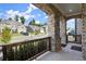 Covered front porch showing brick supports and dark wooden railing, with a view of a quiet street at 7410 Ansley View Ln, Cumming, GA 30028