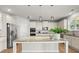 Elegant kitchen with stainless steel appliances, granite countertops, and white cabinets with an island, perfect for cooking at 7410 Ansley View Ln, Cumming, GA 30028