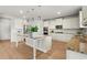Bright kitchen featuring a central island with granite countertops, stainless steel appliances, and white cabinetry at 7410 Ansley View Ln, Cumming, GA 30028