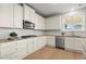 Well-lit kitchen featuring stainless steel appliances, granite countertops, and crisp white cabinets with modern backsplash at 7410 Ansley View Ln, Cumming, GA 30028