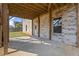 Covered patio with brick pillars and an adjacent green lawn at 7410 Ansley View Ln, Cumming, GA 30028