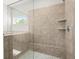 Close up of a luxurious walk-in shower featuring gray stone tiling and built-in shelving at 7410 Ansley View Ln, Cumming, GA 30028
