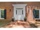 Elegant brick home entrance with black shutters, a white doorframe, and manicured planters at 80 Cliffcreek Trce, Atlanta, GA 30350
