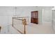 Hallway features carpet, wood railing, and view of decorative cabinet at 80 Cliffcreek Trce, Atlanta, GA 30350