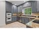 Kitchen with stainless steel appliances and granite counters, complemented by tiled floors and gray cabinets at 80 Cliffcreek Trce, Atlanta, GA 30350