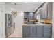Kitchen with stainless steel appliances and granite counters, complemented by tiled floors and gray cabinets at 80 Cliffcreek Trce, Atlanta, GA 30350