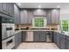 Kitchen with stainless steel appliances and granite counters, complemented by tiled floors and gray cabinets at 80 Cliffcreek Trce, Atlanta, GA 30350