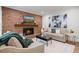 Living room with brick fireplace, plush sofas, neutral rug, and eye-catching artwork, creating a cozy and stylish space at 80 Cliffcreek Trce, Atlanta, GA 30350