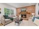 Living room with brick fireplace, plush sofas, neutral rug, and eye-catching artwork, creating a cozy and stylish space at 80 Cliffcreek Trce, Atlanta, GA 30350
