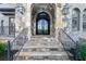 Close-up of the stately stone entryway featuring an arched door and custom iron work at 9695 Almaviva Dr, Alpharetta, GA 30022