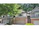 Charming townhouse featuring a two-car garage, brick accents, and mature trees at 109 Creighton Ln, Marietta, GA 30008