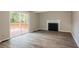 Inviting living room with wood-look floors, a cozy fireplace, and sliding door to the patio at 110 Paddock Trl, Peachtree City, GA 30269