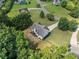 An aerial view of a well-maintained home, showcasing its backyard with trees and a cozy patio area at 2355 Woodland Hills Dr, Cumming, GA 30040