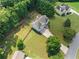 This aerial view reveals a charming house with a sprawling lawn, complemented by mature trees and a lengthy driveway at 2355 Woodland Hills Dr, Cumming, GA 30040