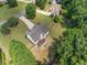 Aerial view of the home's setting surrounded by mature trees, lawns, and a long driveway at 2355 Woodland Hills Dr, Cumming, GA 30040