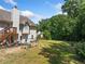 Large backyard with a deck, grass area, landscaping, and mature trees, ideal for outdoor activities at 2355 Woodland Hills Dr, Cumming, GA 30040