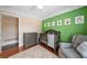 Bedroom features a green accent wall, wood floors, gray crib and chair with large windows at 2355 Woodland Hills Dr, Cumming, GA 30040