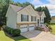 Charming two-story home with a stone foundation, two-car garage and well-manicured lawn at 2355 Woodland Hills Dr, Cumming, GA 30040