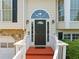 Close-up of the front door with sidelights, transom window, and red stairs at 2355 Woodland Hills Dr, Cumming, GA 30040