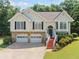 Charming split-level home with stone accents, two-car garage and inviting, red-painted staircase at 2355 Woodland Hills Dr, Cumming, GA 30040