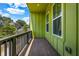 View of an outdoor balcony area with painted green siding, and a wooded view beyond at 2022 Bixby Byway Se Rd, Atlanta, GA 30317