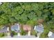 An aerial view displays houses interspersed among mature trees in a well-established neighborhood at 457 Skiles Ct, Suwanee, GA 30024