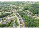 A scenic aerial shot reveals the neighborhood's layout amidst mature trees at 457 Skiles Ct, Suwanee, GA 30024