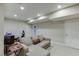 Well-lit basement with neutral walls, carpet, and a sectional couch, perfect for lounging and recreation at 457 Skiles Ct, Suwanee, GA 30024