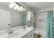 Bathroom features a double sink vanity, tub, and decorative shower curtain at 457 Skiles Ct, Suwanee, GA 30024