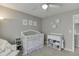 Neutral bedroom with a white crib, changing table and decor on the walls at 457 Skiles Ct, Suwanee, GA 30024