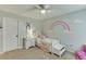 Cozy bedroom with a rainbow mural and comfortable furniture at 457 Skiles Ct, Suwanee, GA 30024