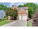 View of the two-car garage and brick exterior of this lovely traditional home at 457 Skiles Ct, Suwanee, GA 30024