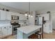 Updated kitchen featuring stainless appliances, a center island, white cabinets, and modern lighting fixtures at 457 Skiles Ct, Suwanee, GA 30024
