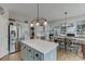 Open-concept kitchen with stainless steel appliances, a center island, and seamless flow to the dining and living areas at 457 Skiles Ct, Suwanee, GA 30024