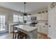 Bright kitchen with white cabinets, stainless steel appliances, an island with seating, and backyard access at 457 Skiles Ct, Suwanee, GA 30024